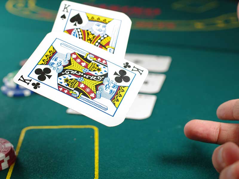 Spielkarten auf den Pokertisch werfen